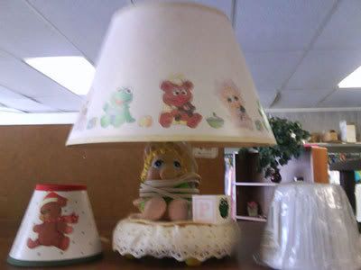 Baby Miss Piggy lamp, with lamp cord wrapped around Miss Piggy so she looks like she's being held hostage.